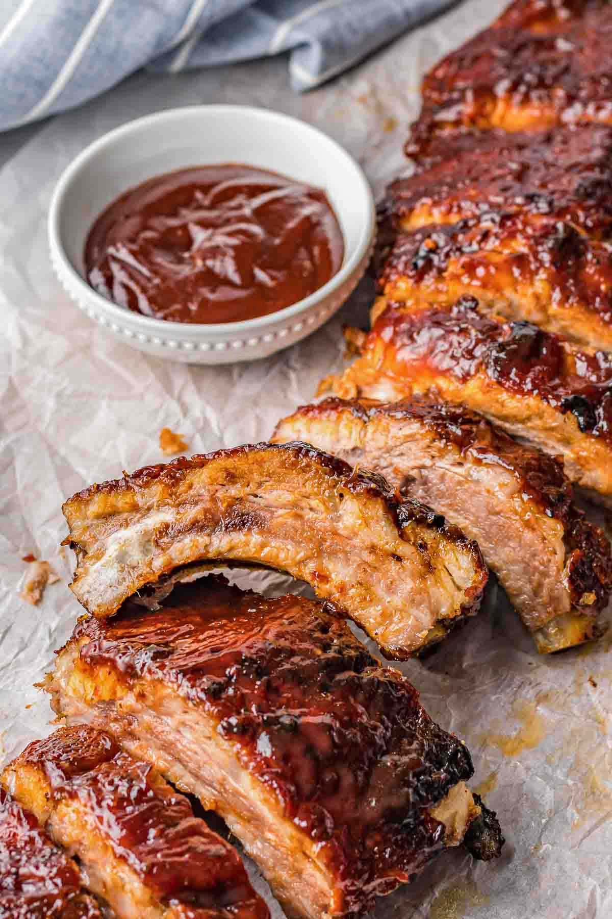 A seperated barbecue baby back ribs served with additional BBQ sauce