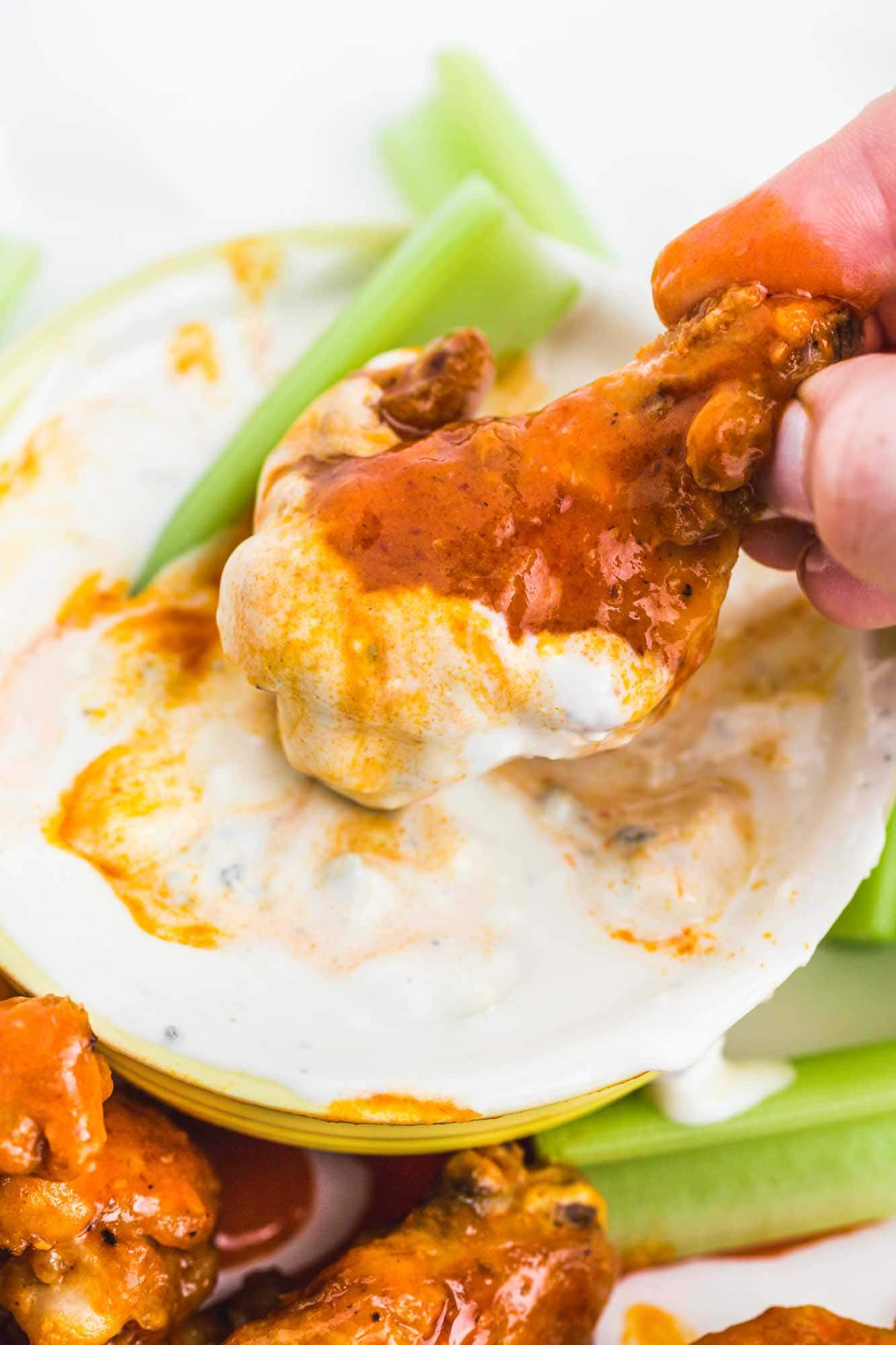 Dipping a buffalo chicken wing (drumette) in blue cheese dip