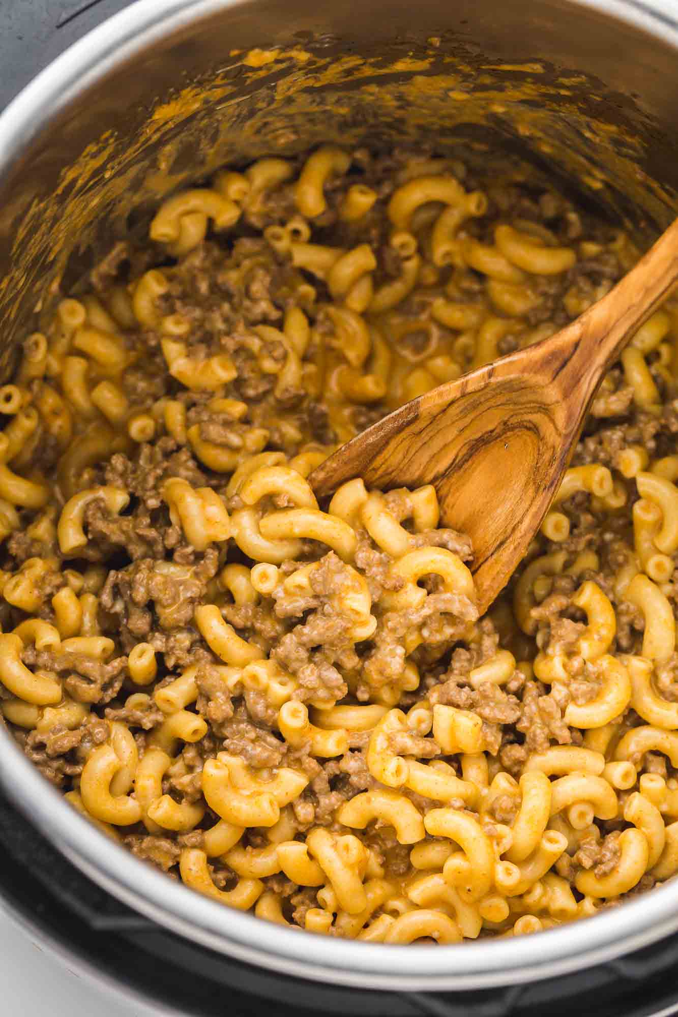 Homemade hamburger helper in the Instant Pot with a wooden spoon