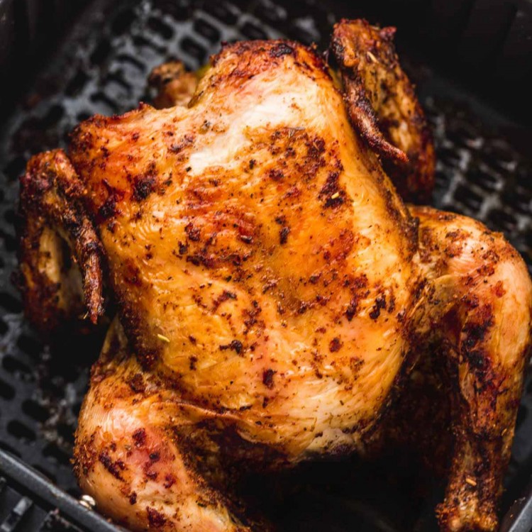 Roasted whole chicken in an air fryer basket