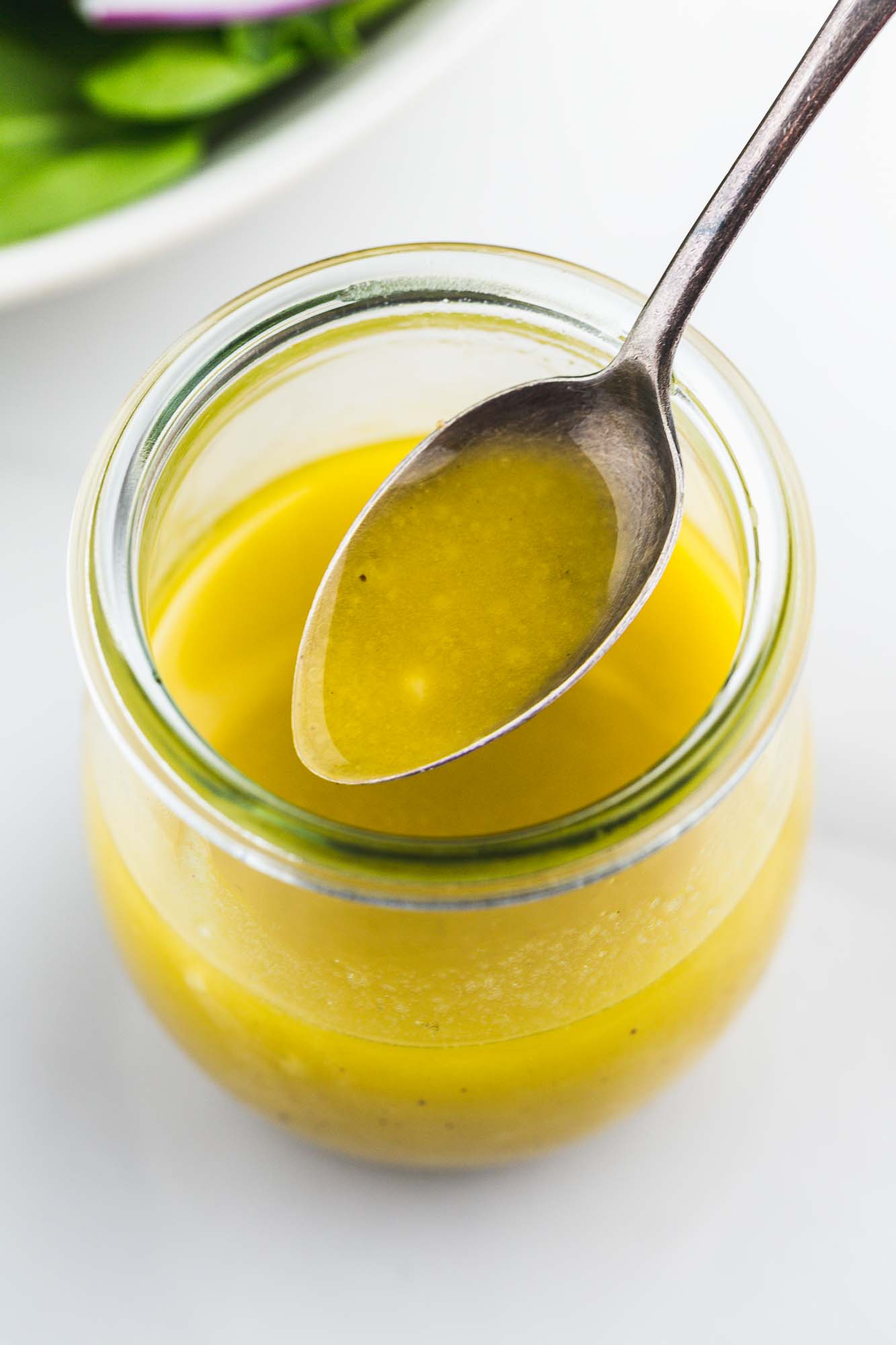 apple cider vinaigrette in a jar with a spoon