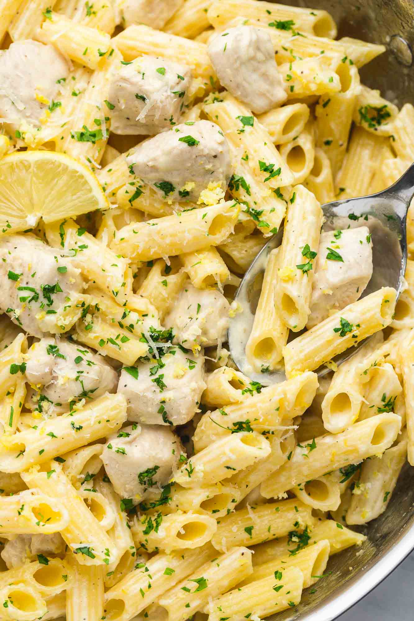 Creamy Lemon Chicken Pasta in a stainless steel pan with a serving spoon
