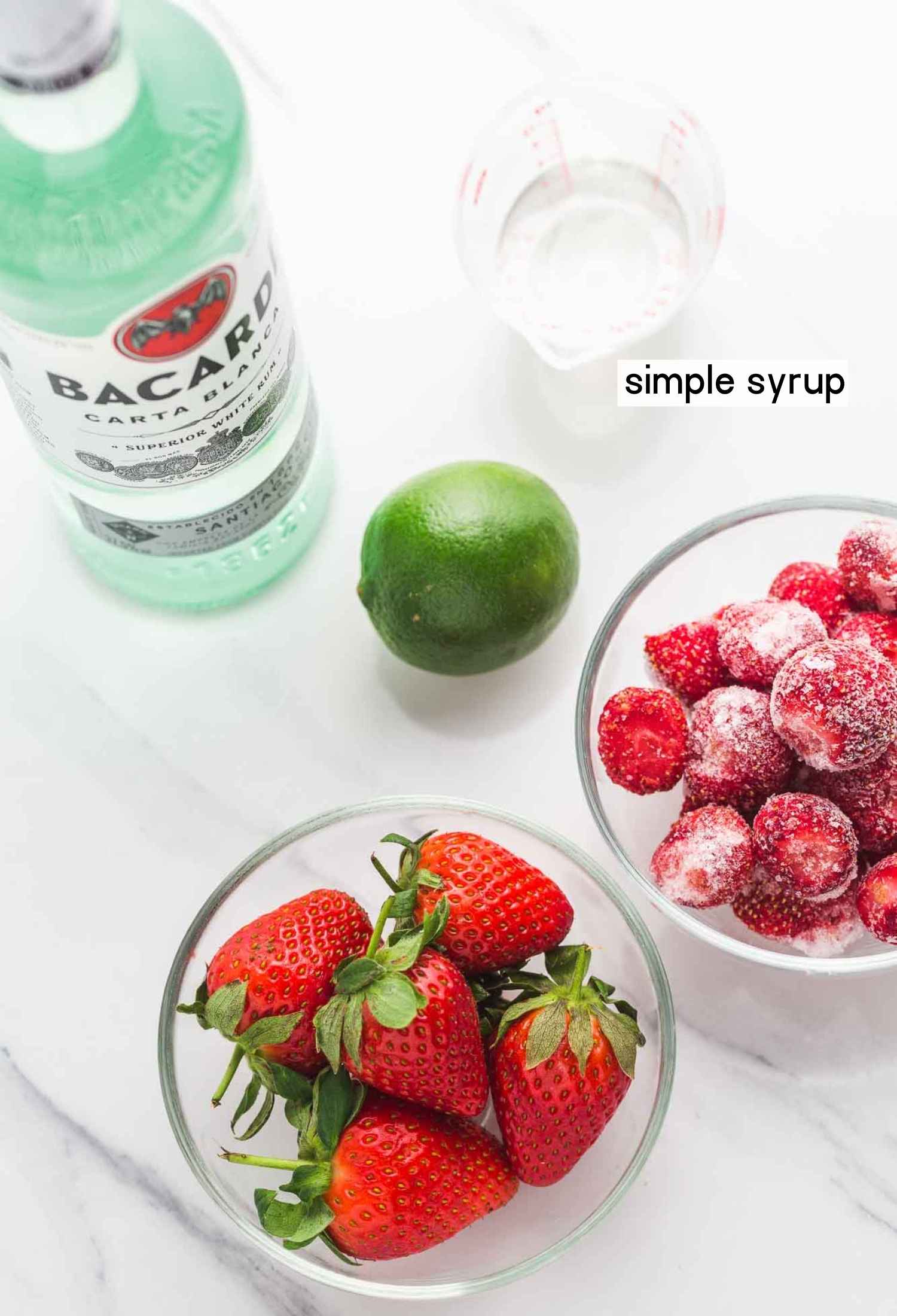 Ingredients needed to make strawberry daiquiri: strawberries (Fresh and frozen), rum, lime, simple syrup.