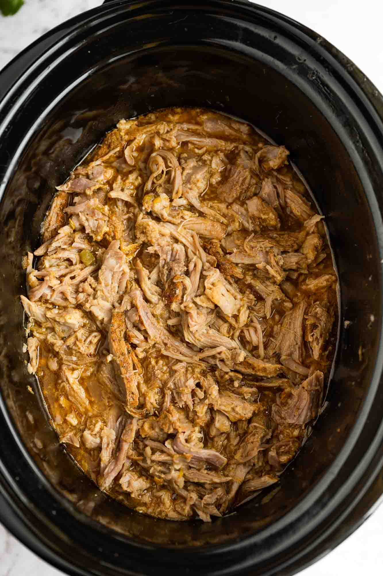 Carnitas in a black slow cooker