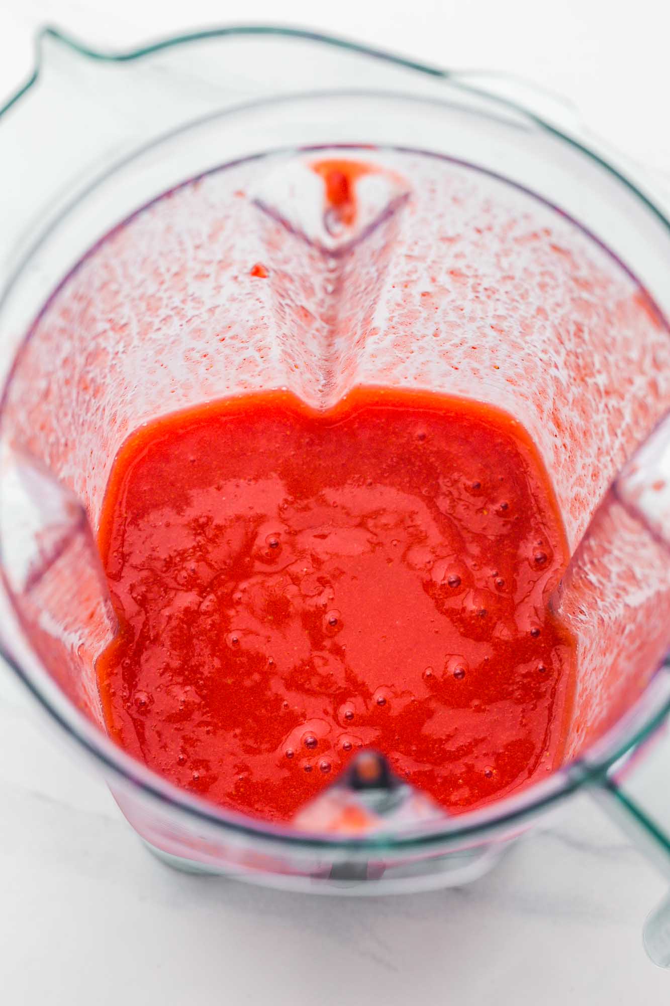 Blended strawberry daiquiri in a blender jug.