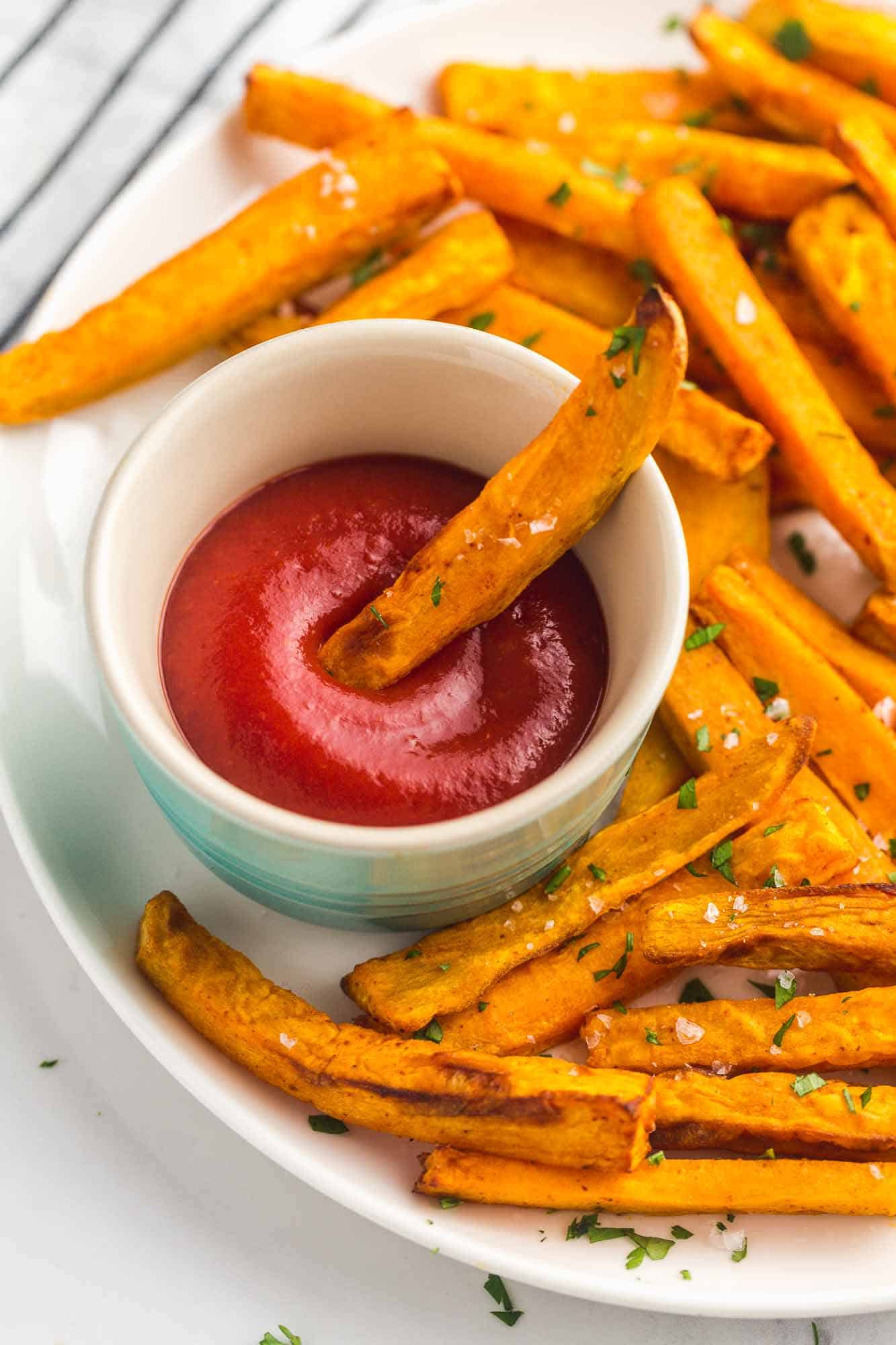 Sweet potato fries dipped in ketchup