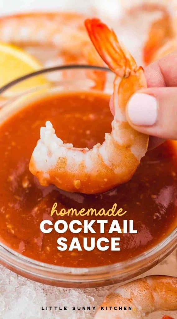 Dipping a perfectly cooked jumbo shrimp in cocktail sauce with overlay text "homemade cocktail sauce"