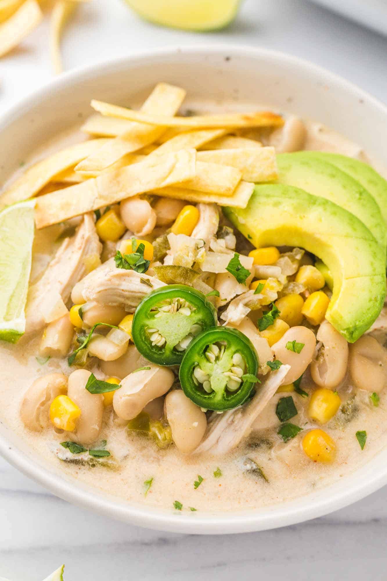 Crockpot White Chicken Chili served in a white bowl with toppings