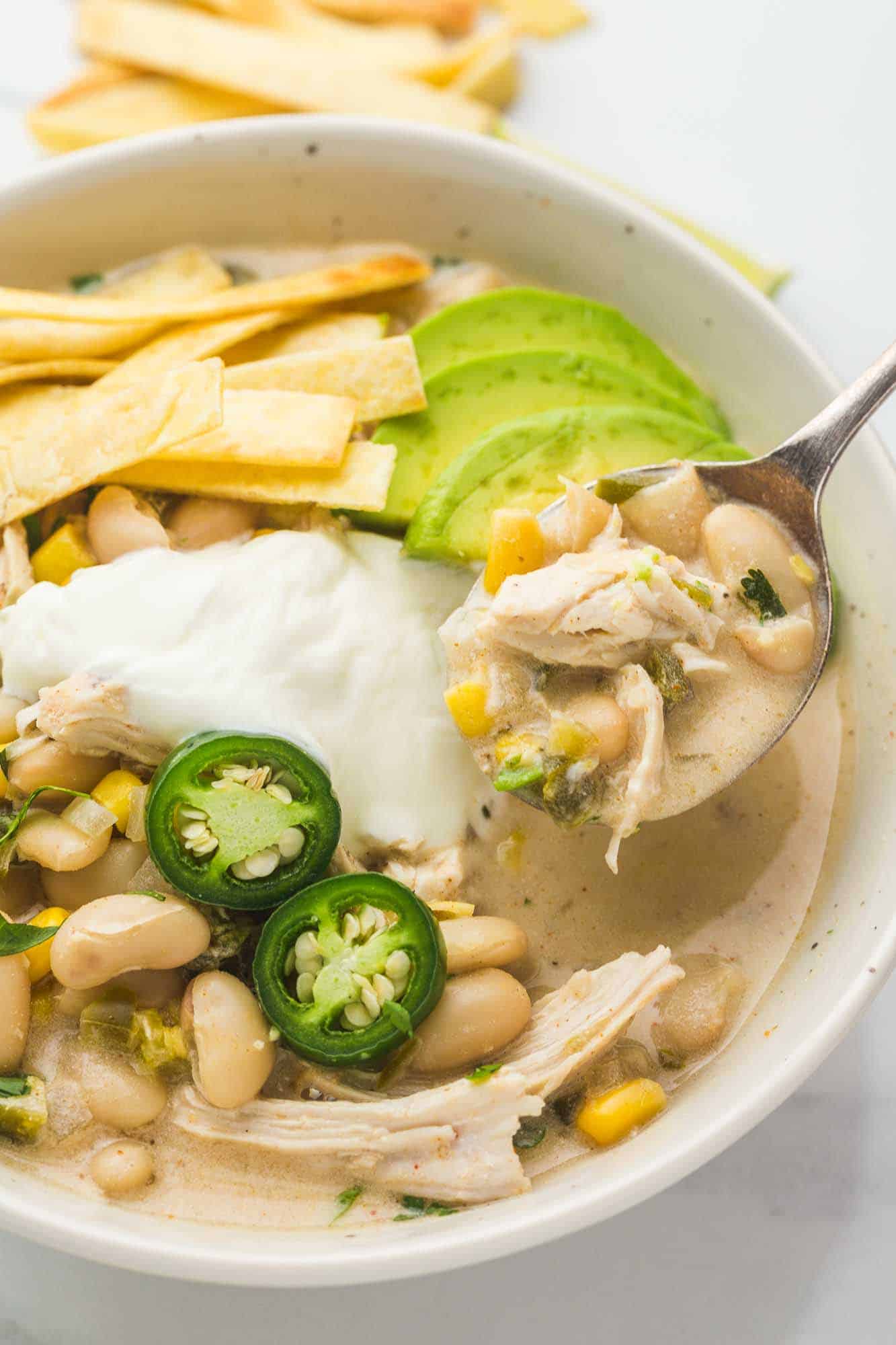 White chili in a white bowl and a spoon