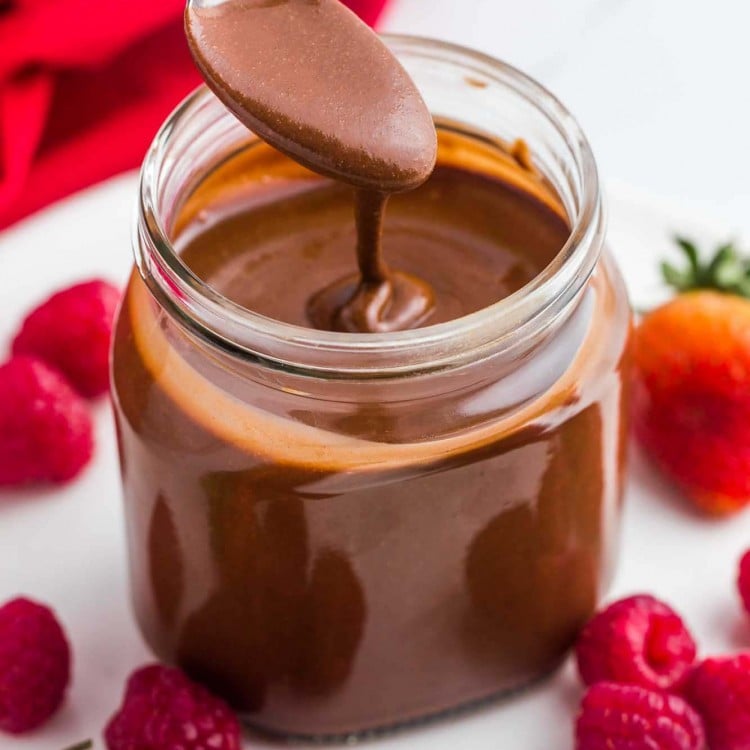 Homemade Nutella with a spoon and fresh berries