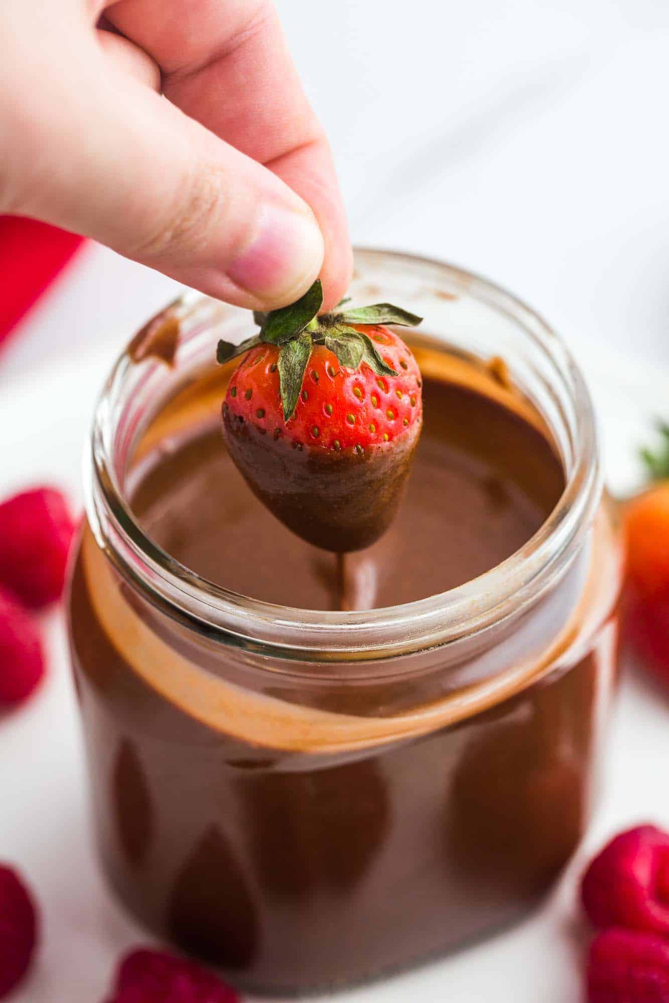 Dipping a fresh strawberry in homemade nutella