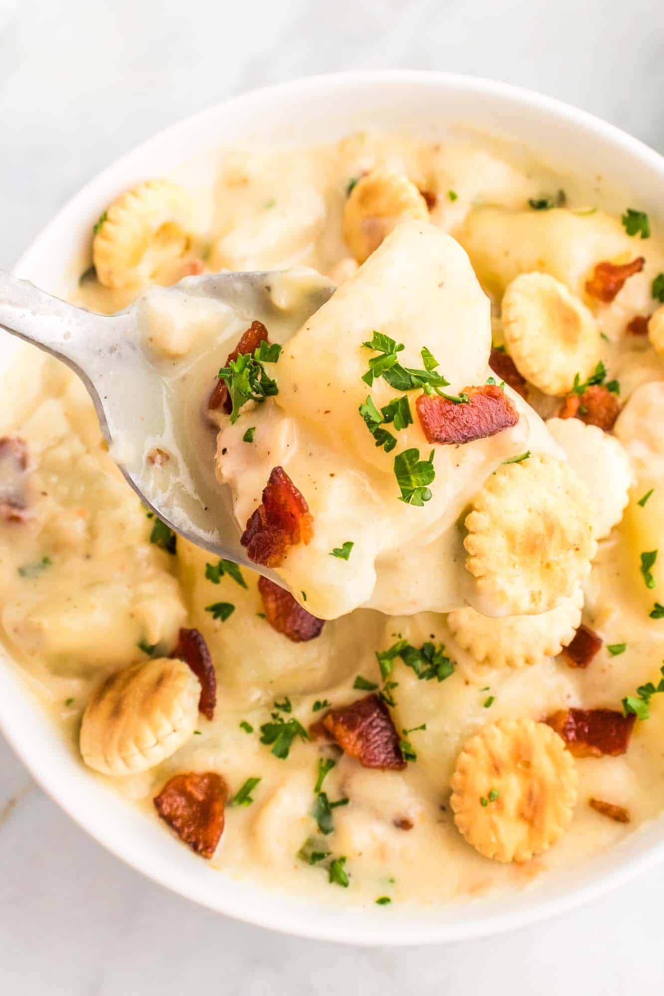 A spoonful of clam chowder and crispy bacon