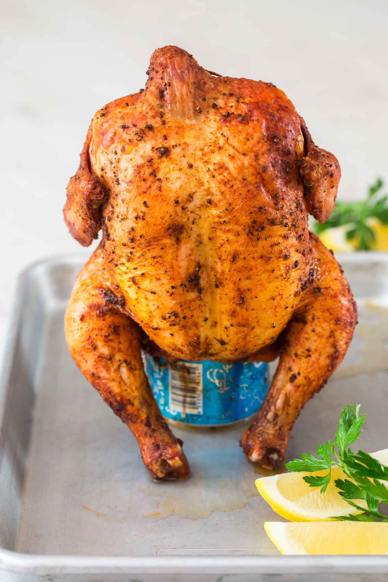 Beer can chicken (grilled) placed on a quarter sheet pan