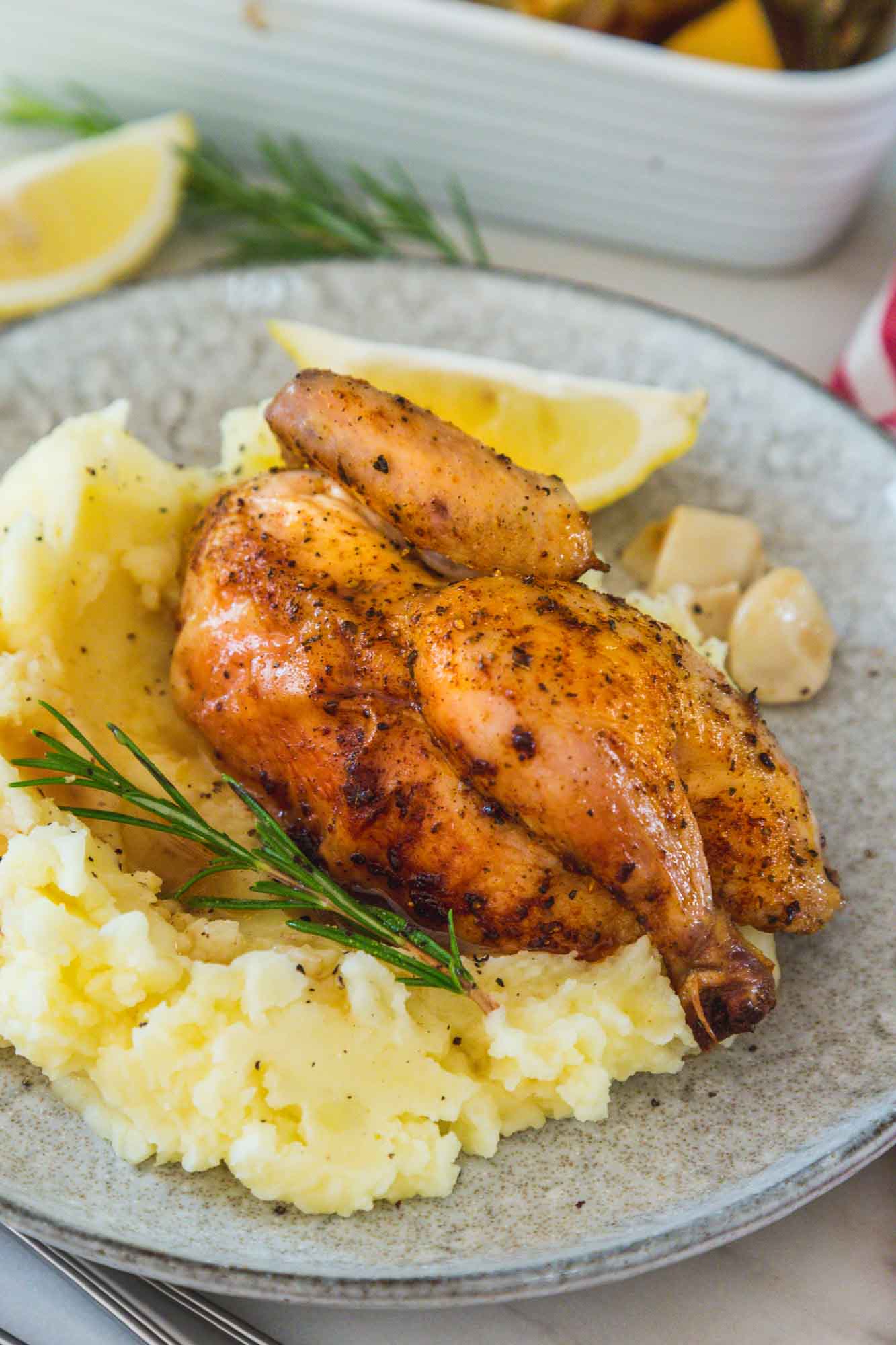 Half a roasted cornish hen served with mashed potatoes