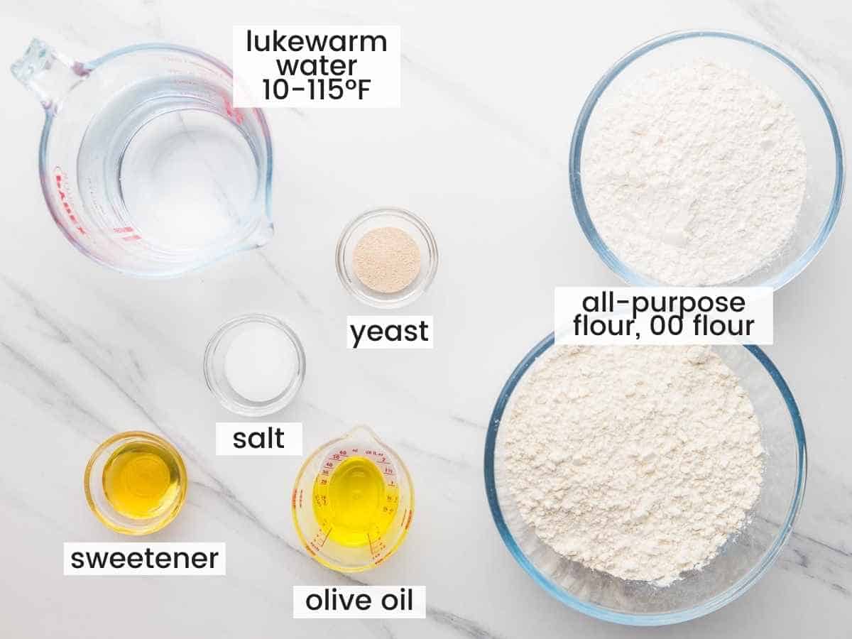 Ingredients needed to make pizza dough including flour, yeast, honey, water, olive oil, and salt.