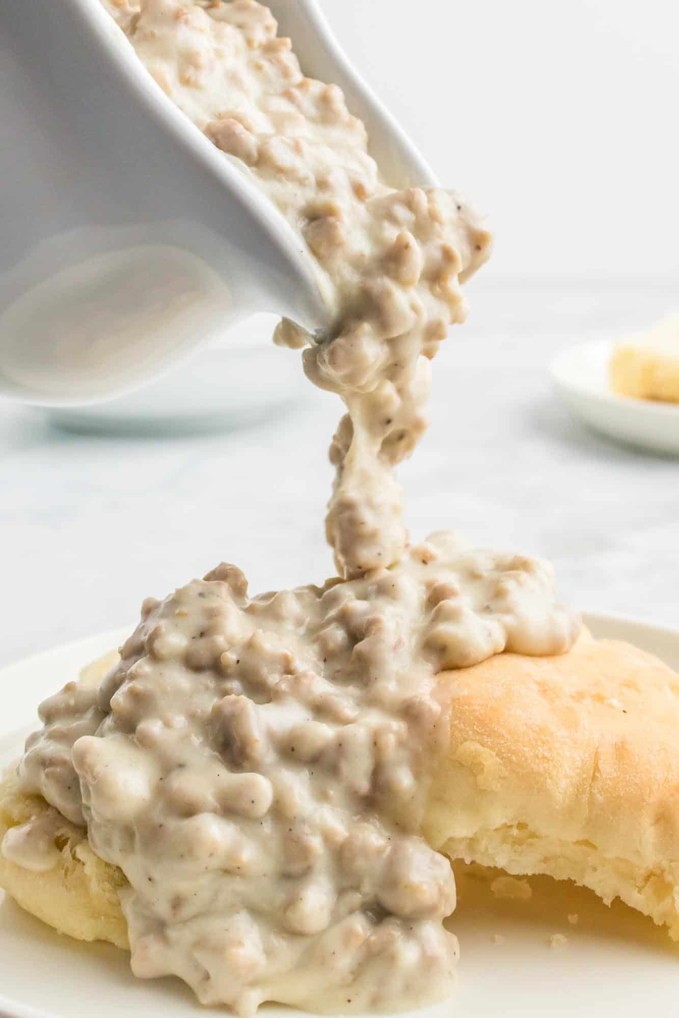 Pouring sausage gravy over biscuits