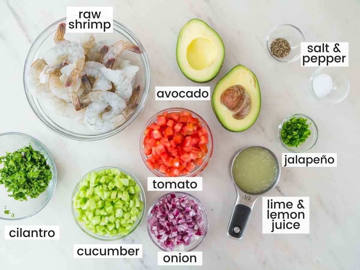 Ingredients needed to make shrimp ceviche including raw shrimp, avocadoes, tomato, cucumber, red onion, citrus juice, jalapeno, cilantro, salt and pepper.