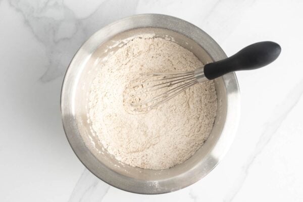 Dry ingredients mixed in a bowl with a whisk
