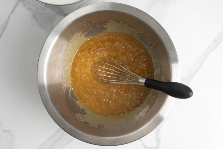Wet ingredients mixed in a bowl with a whisk