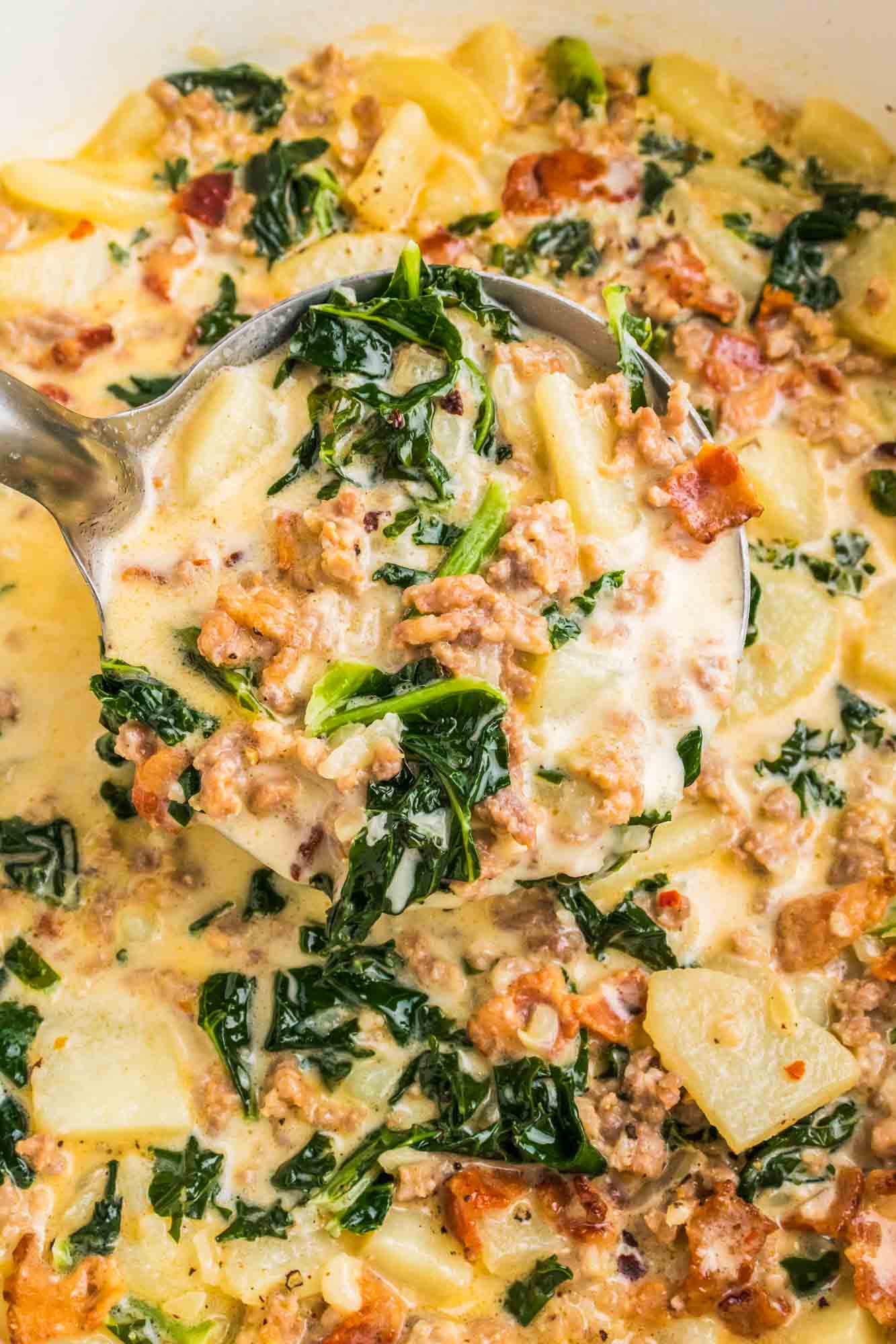 Zuppa Toscana in a cast iron pot with a soup ladle