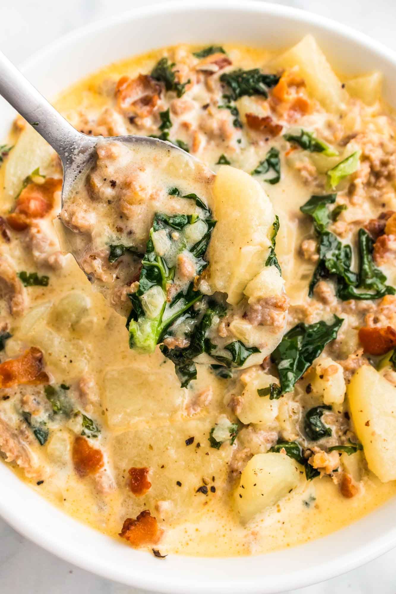 Zuppa toscanna in a white bowl with a spoon