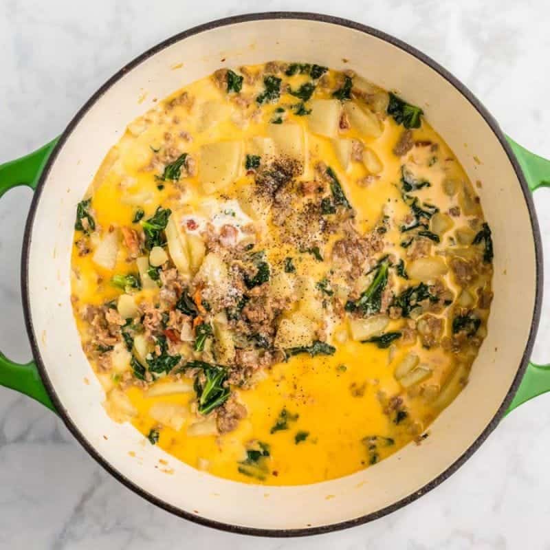 Finished Zuppa Toscana soup with sausage, potatoes, kale, and creamy broth in a pot