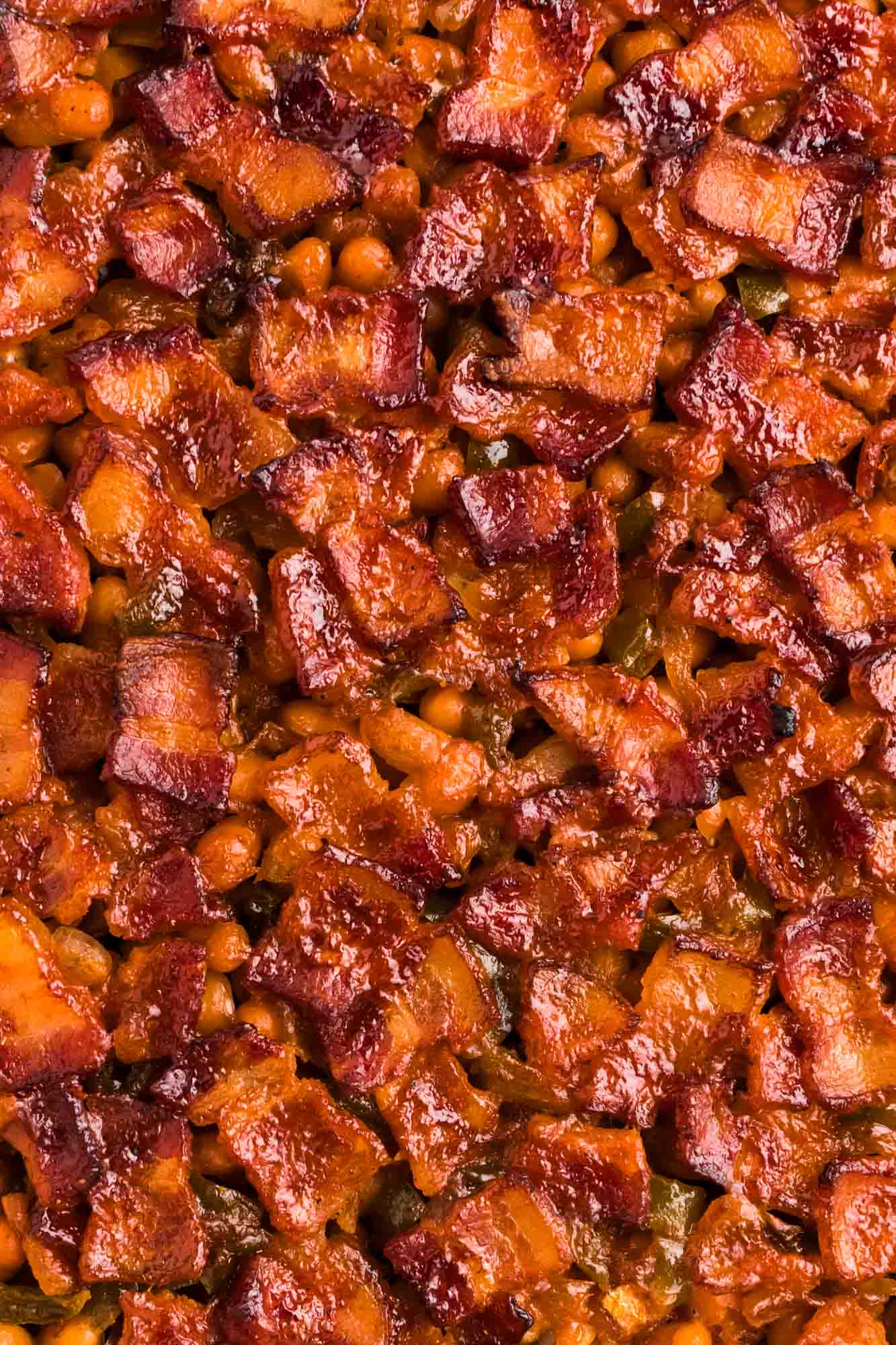 close up shot of baked beans covered with bacon