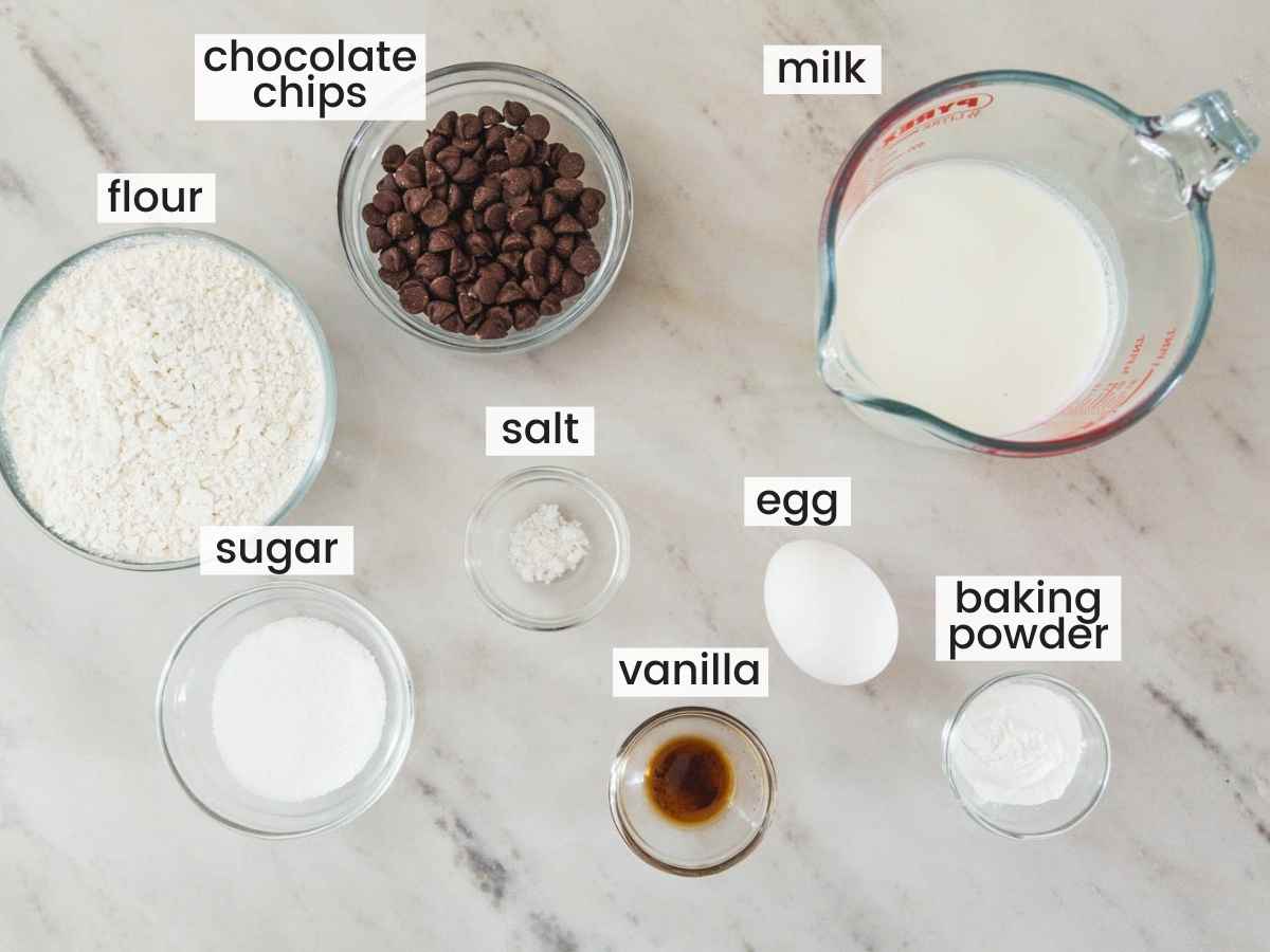 Ingredients needed for chocolate chip pancakes including flour, chocolate chips, milk, baking powder, sugar, salt, and vanilla.