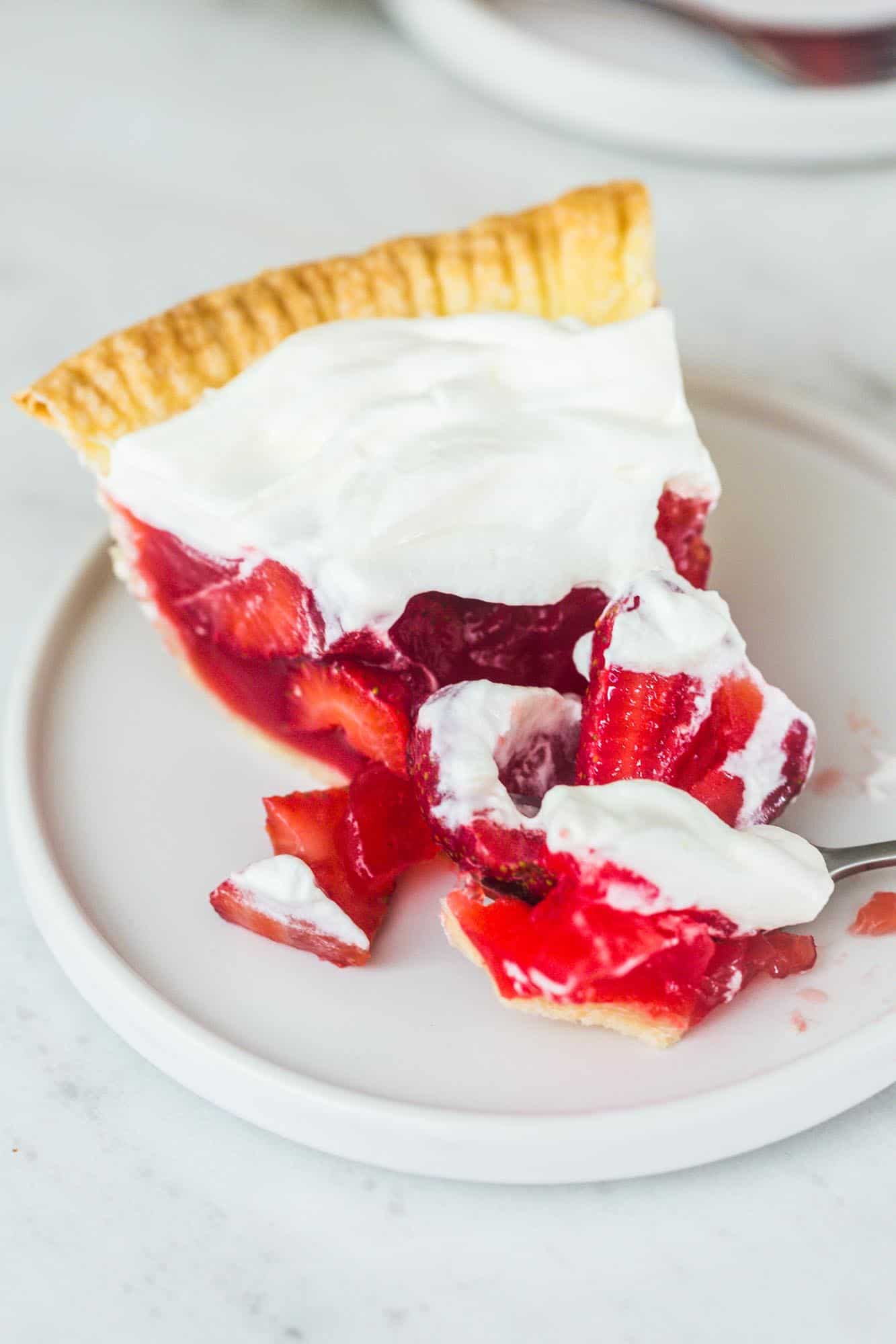 Eating a slice of strawberry pie by breaking it up with a fork