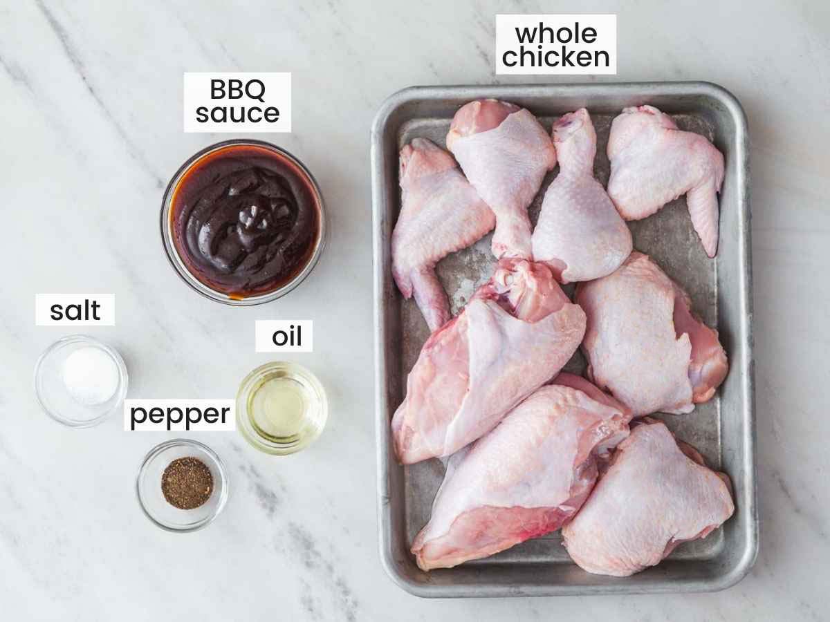 Ingredients needed to make grilled BBQ Chicken, including one whole chicken broken down into 8 pieces, BBQ sauce, oil, salt and pepper.