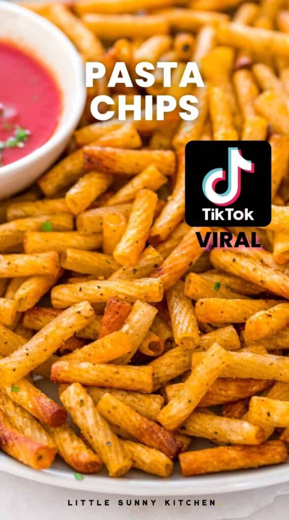Pasta chips served on a large plate, with a tomato dip on the side. With overlay text "Pasta Chips" and a tiktok viral logo on the side.