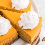 Taking a slice of pumpkin cheesecake with whipped cream