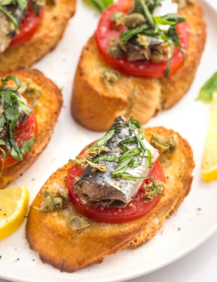 Sardines on Toast with tomato slices, capers, and basil.