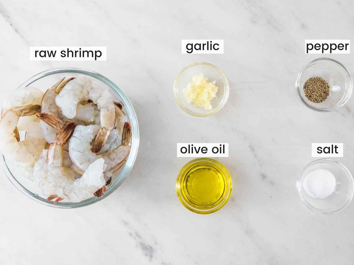 Ingredients needed to air fry shrimp including shrimp, olive oil, garlic, salt, and pepper.