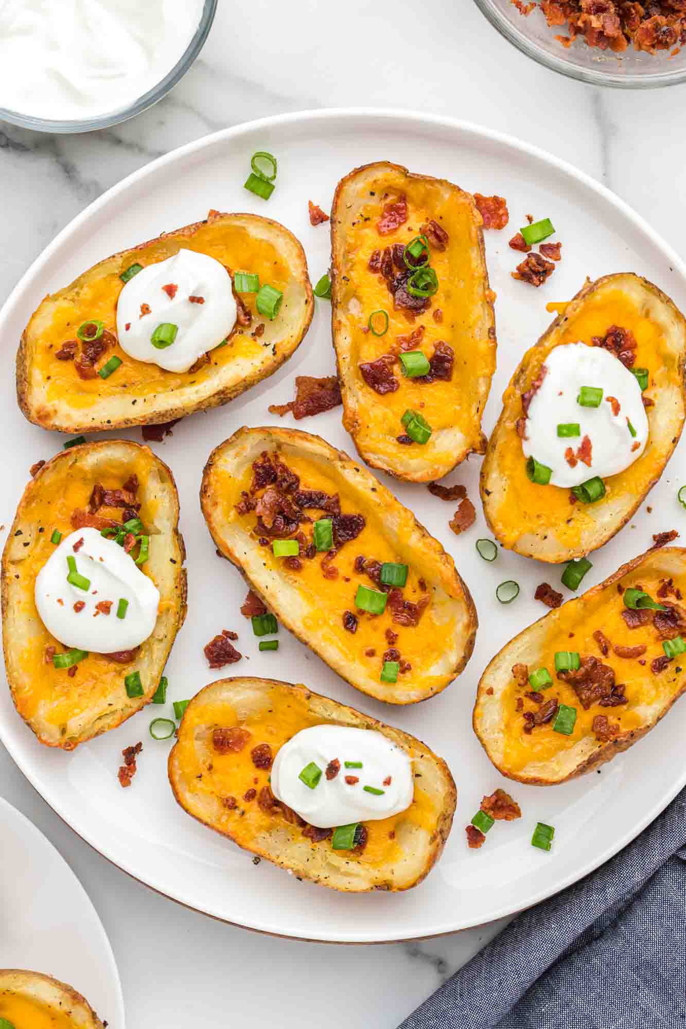 Overhead shot of baked potato skins served on a white plate