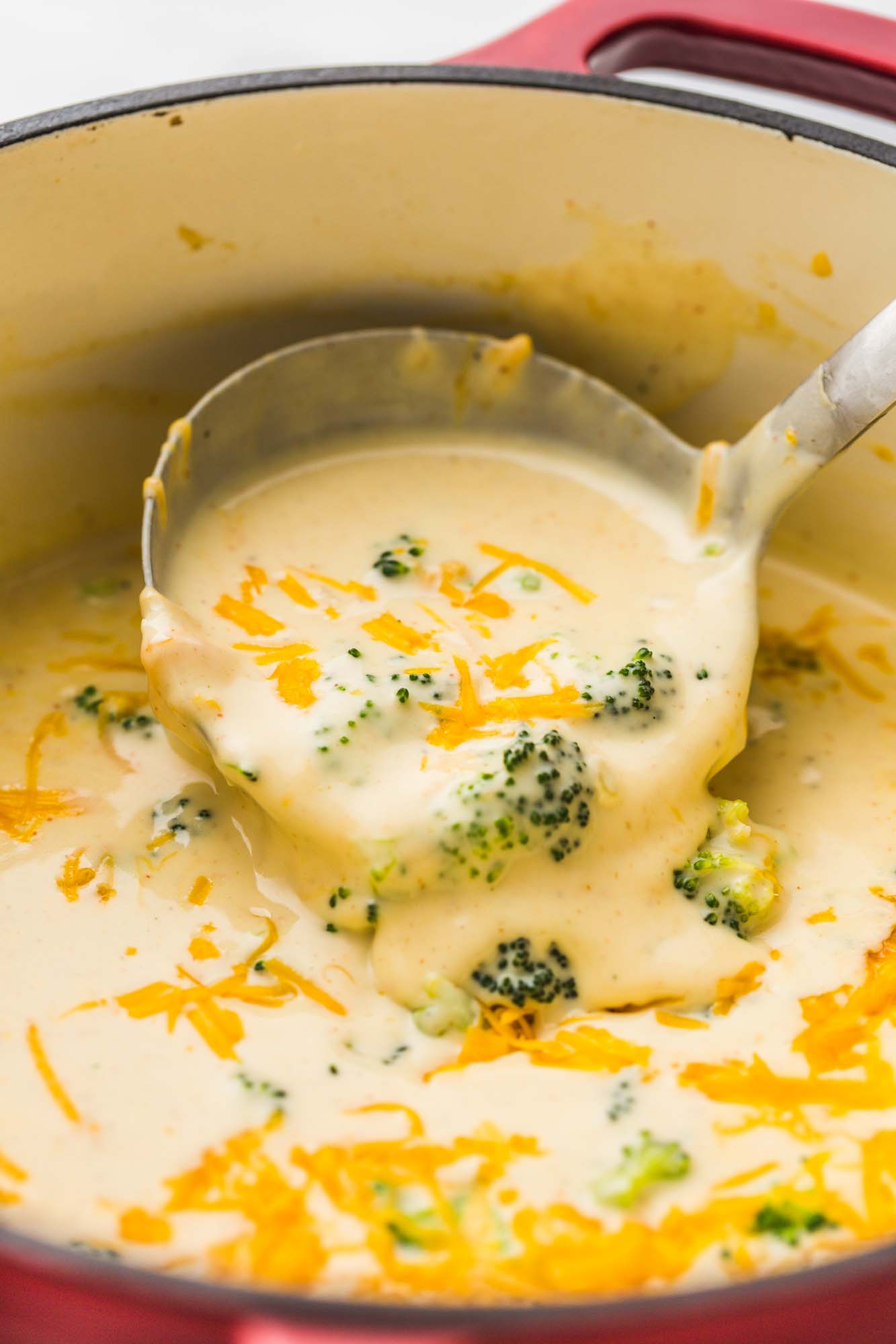 Serving the soup with a ladle from a red dutch oven