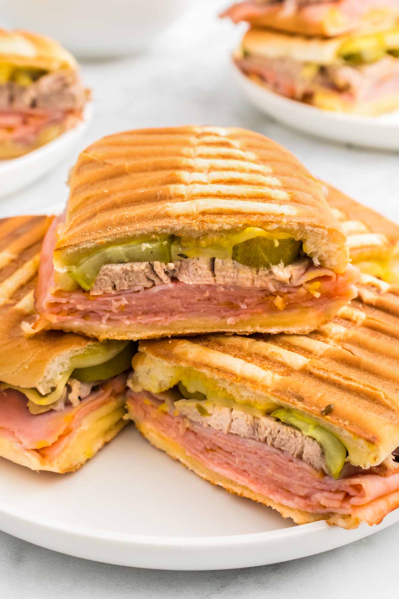 3 Cuban sandwiches served on a white plate