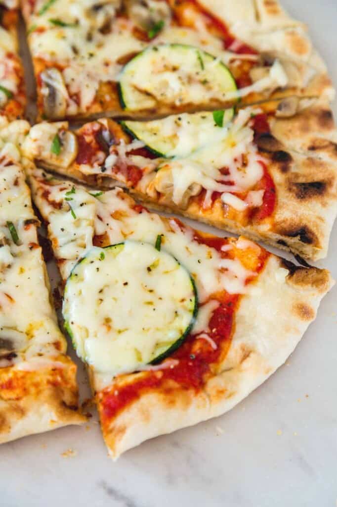 Slices of grilled pizza on a white marble countertop