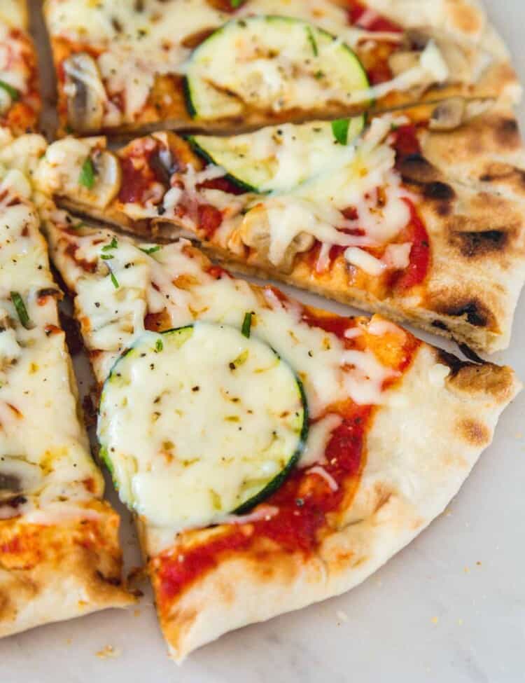 Slices of grilled pizza on a white marble countertop