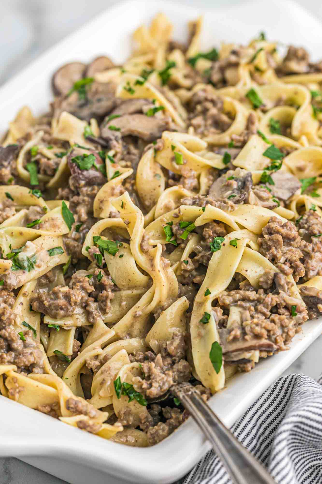 Ground beef stroganoff with egg noodles served in a white casserole dish