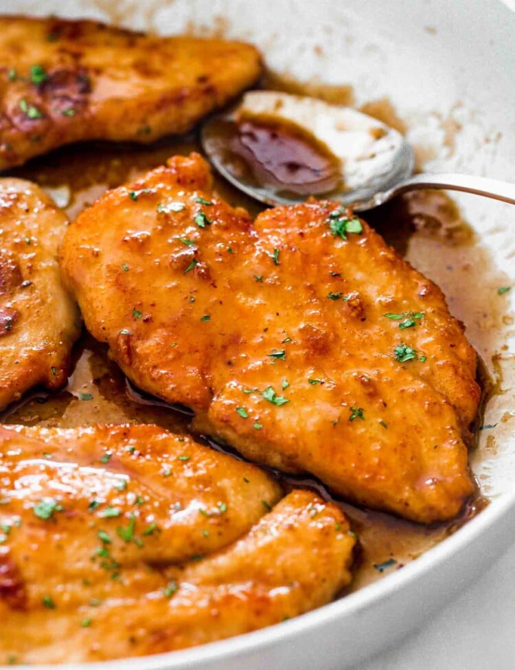 Honey garlic chicken breast cutlets in a skillet with extra sauce