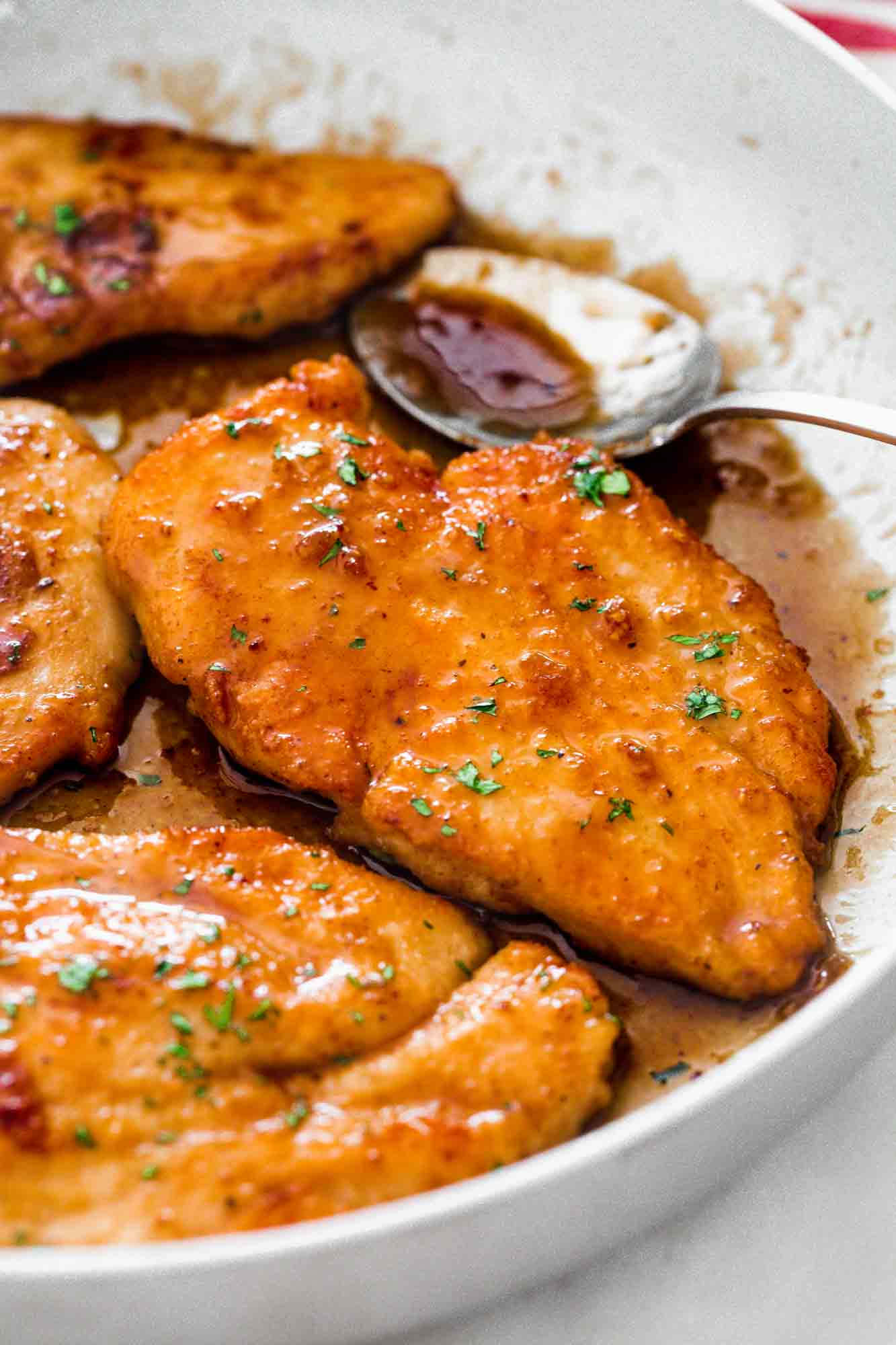 Honey garlic chicken breast cutlets in a skillet with extra sauce