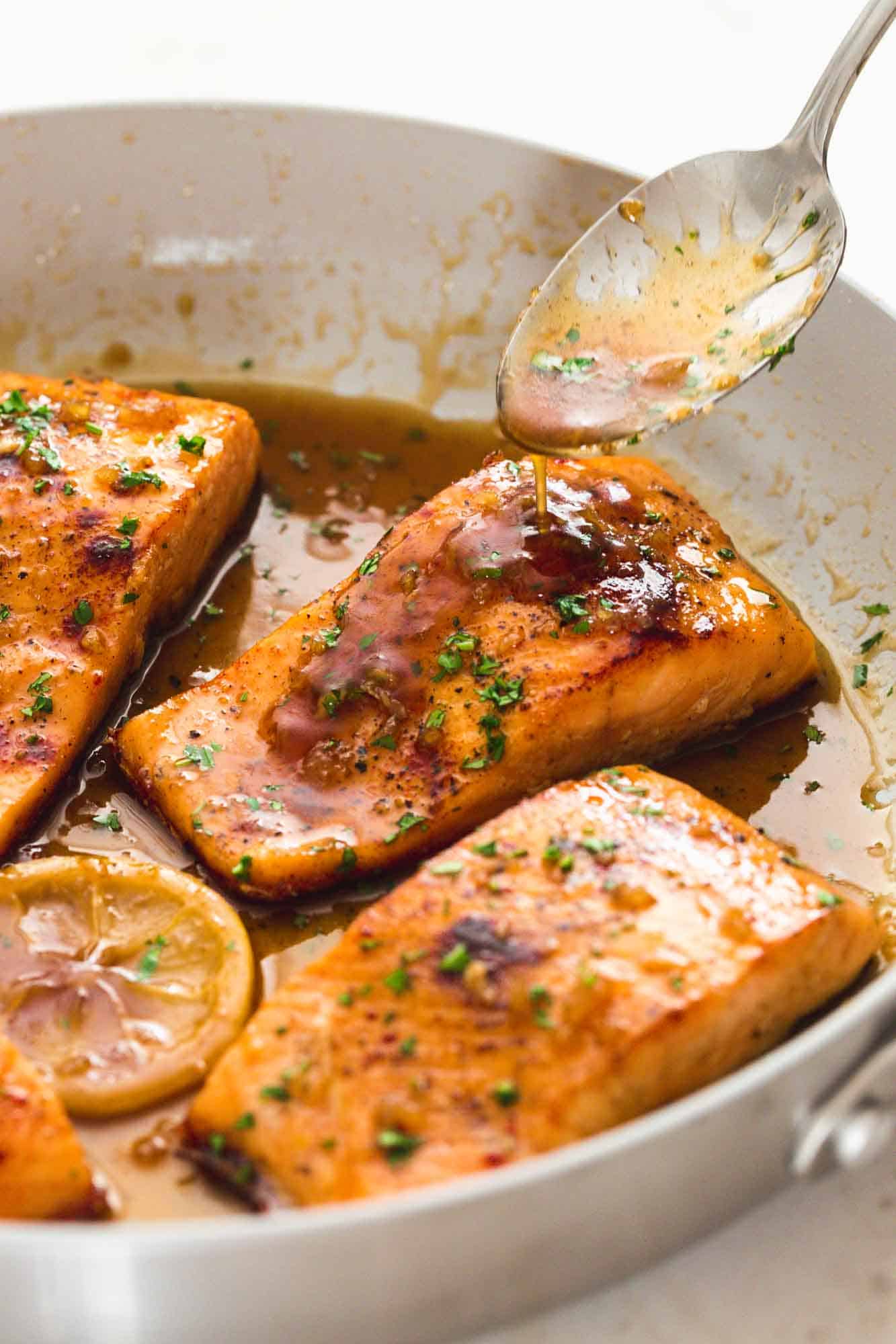 Spooning honey garlic sauce over salmon