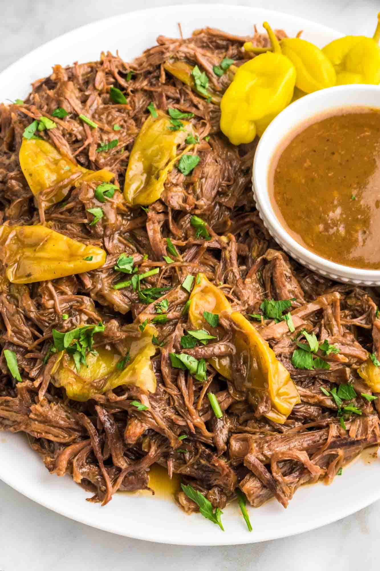  Instant Pot Mississippi Pot Roast plated on a white plate with sauce on the side