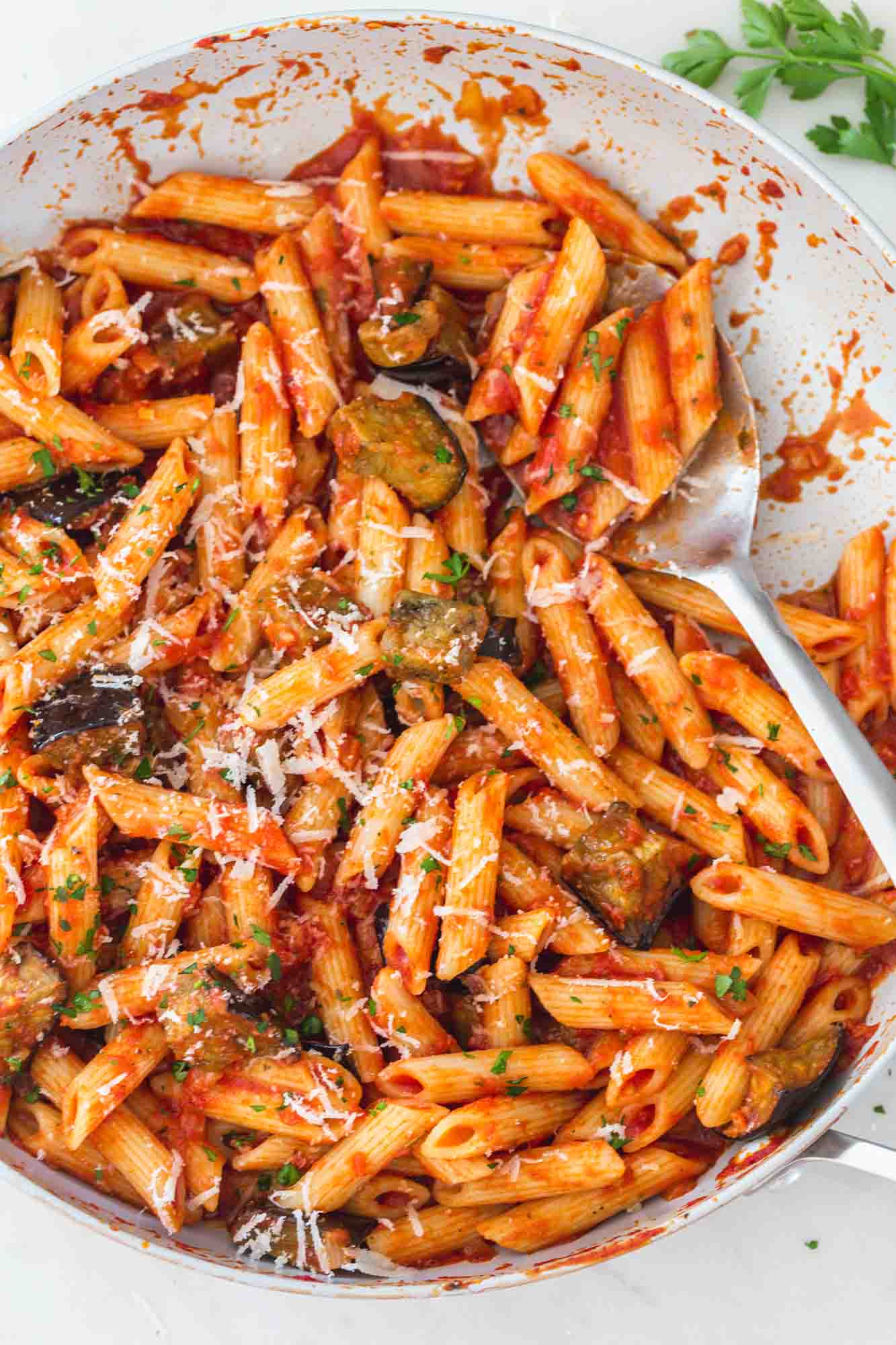 eggplant pasta in a large skillet with a serving spoon