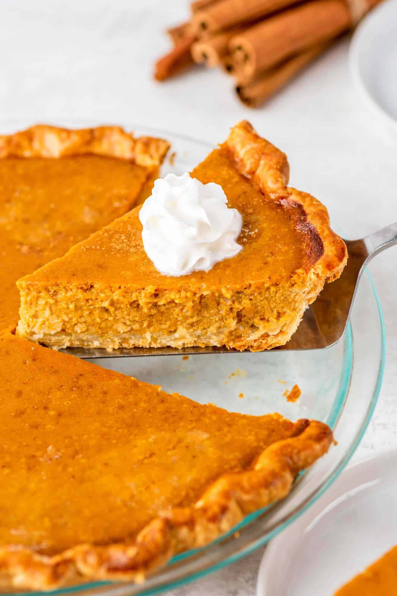 Taking a slice of pumpkin pie, topped with whipped cream