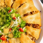 Overhead shot of a taco ring served with salad and guacamole in the middle