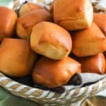 Texas roadhouse rolls stacked in a bread basket