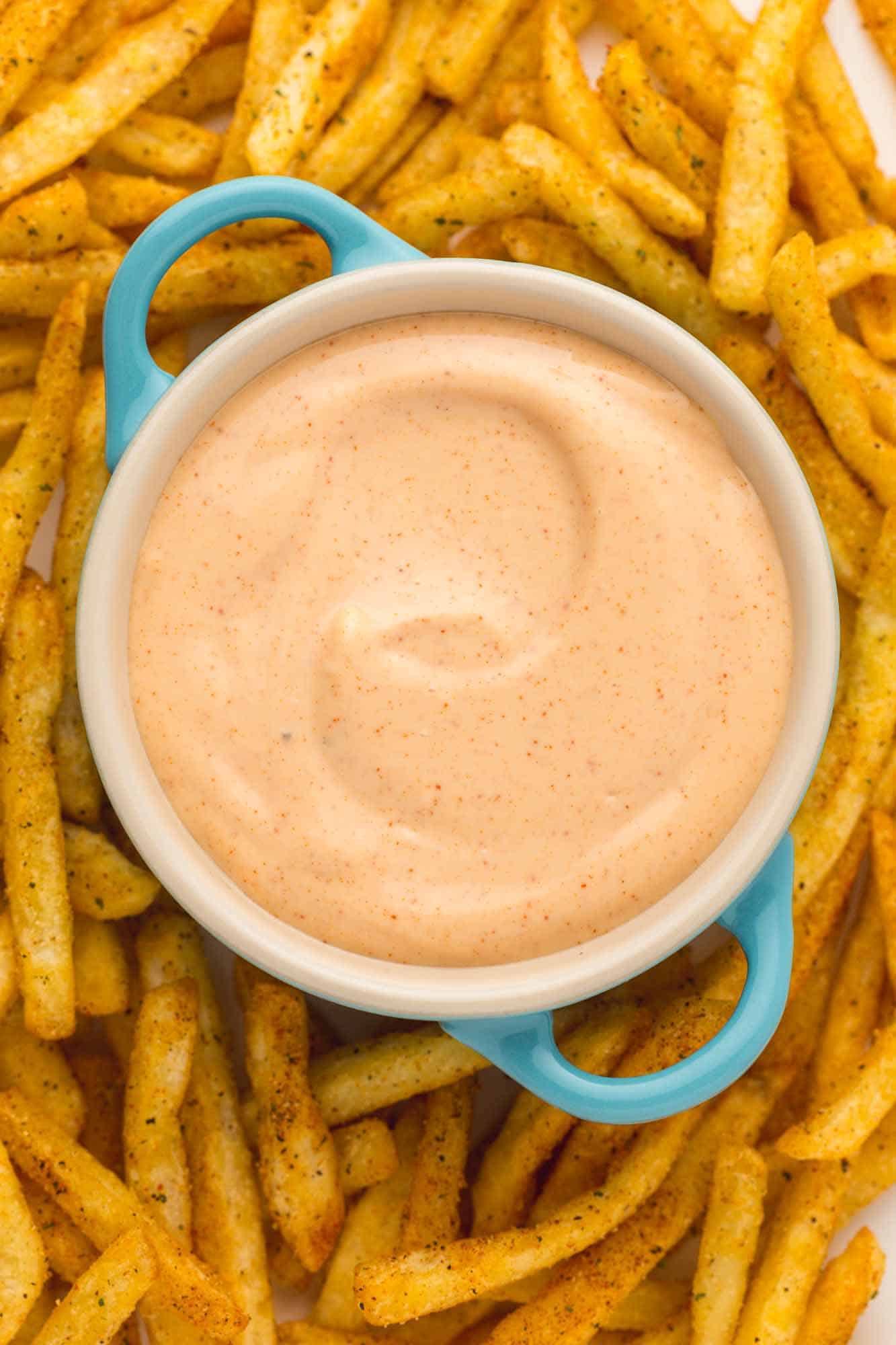 Overhead shot of fry sauce served in a blue dish, and fresh fries.
