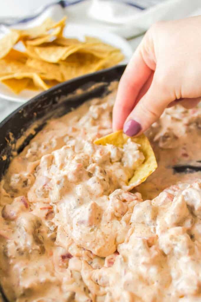 Dipping into sausage dip with a chip